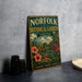 A vintage-style metal sign for the Norfolk Botanical Garden in Virginia, featuring a colorful illustration of a garden with flowers, plants, and a greenhouse.