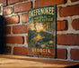 A vintage-style metal sign for the Okefenokee National Wildlife Refuge in Georgia, featuring a serene landscape with a heron and a sunset over a body of water.