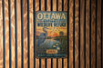 A vintage metal sign for the Ottawa National Wildlife Refuge, featuring an illustration of a crane and a sunset over a lake.