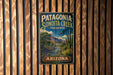A vintage metal sign for Patagonia Sonoita Creek Preserve in Arizona, featuring a desert landscape with a cactus and a bird in flight.