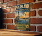 A vintage-style metal sign for the Pea Island National Wildlife Refuge in North Carolina, featuring a heron and a lighthouse in a coastal landscape.