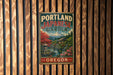 A vintage metal sign for the Portland Japanese Garden in Oregon, featuring a scenic landscape with a mountain, pagoda, and cherry blossom trees.