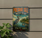 A vintage metal sign for Presque Isle, Pennsylvania, featuring a large bird and a lighthouse in the background.