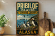 A vintage-style sign for the Pribilof Islands, Alaska, featuring illustrations of puffins and a scenic coastal landscape.