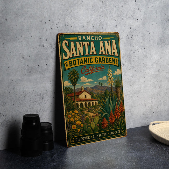 A vintage-style metal sign for the Rancho Santa Ana Botanic Garden in California, featuring a colorful illustration of a desert landscape with a house and various plants.