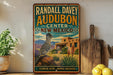 A vintage-style metal sign for Randall Davey Audubon Center in New Mexico, featuring a colorful illustration of a bird and desert landscape.