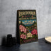 A vintage-style metal sign for the Rhododendron Species Botanical Garden in Washington, featuring a scenic landscape with a mountain and colorful flowers.
