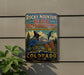 A vintage-style metal sign for the Rocky Mountain Bird Observatory in Colorado, featuring a blue bird and a mountainous landscape.