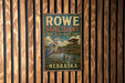 A vintage metal sign for Rowe Sanctuary Audubon in Nebraska, featuring an illustration of a bird and a building.