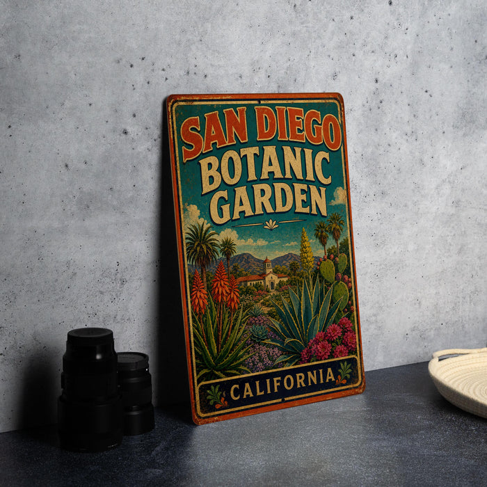 A vintage-style metal sign for the San Diego Botanic Garden in California, featuring an illustration of a tropical garden landscape.