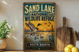 A vintage-style metal sign for the Sand Lake National Wildlife Refuge in South Dakota, featuring an illustration of ducks and other wildlife in a natural setting.