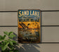 A vintage-style metal sign for the Sand Lake National Wildlife Refuge in South Dakota, featuring an illustration of ducks and other wildlife in a natural setting.