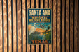 A vintage-style metal sign for the Santa Ana National Wildlife Refuge in Texas, featuring a white egret and palm trees against a sunset backdrop.