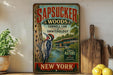 a vintage-style sign for Sapucker Woods, a college in New York, with a woodpecker illustration. The sign is displayed on a shelf next to a wooden cutting board and some lemons.