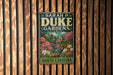 A vintage-style metal sign for "Sara P Duke Gardens North Carolina" is displayed on a wooden wall.