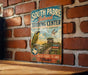 A vintage-style sign for the South Padre Island Birding Center in Texas, featuring a bird illustration and text promoting birdwatching and conservation.