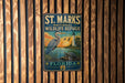 A vintage-style metal sign for St. Marks National Wildlife Refuge in Florida, featuring an illustration of a heron and a lighthouse.