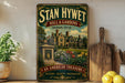 A vintage-style sign for "Stan Hywet Hall & Gardens" in Akron, Ohio, featuring a large illustration of a historic building surrounded by a garden.