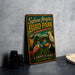 A vintage-style metal sign for Sylvan Heights Bird Park, featuring colorful illustrations of various birds, is displayed on a gray countertop next to a stack of black camera lenses.