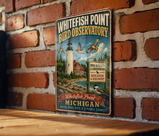 A vintage-style metal sign for the Whitefish Point Bird Observatory, featuring a lighthouse and birds in flight, mounted on a brick wall.