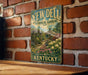 A vintage-style metal sign for Yew Dell Botanical Gardens in Kentucky, featuring a garden scene with a gazebo and flowers.