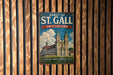 A vintage metal sign for the Abbey of St. Gall in Switzerland, featuring an illustration of the historic building and surrounded by wooden slats.