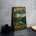 A vintage metal sign for Abbott State Forest in New Hampshire, featuring a scenic landscape with pine trees, a lake, and mountains.