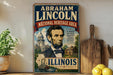 A vintage-style metal sign featuring an illustration of Abraham Lincoln, with text indicating that he is the National Heritage Area of Illinois.