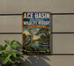A vintage-style metal sign for the Ace Basin National Wildlife Refuge in South Carolina, featuring an illustration of a heron and a tropical landscape.