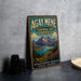 A vintage-style sign for Agay Mene Territorial Park Yukon, featuring a scenic mountain landscape with a lake and pine trees.