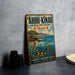 A vintage-style metal sign advertising the "AHII-KINAU Natural Area Reserve" in Hawaii, featuring a scenic landscape with a beach, mountains, and a sea turtle.
