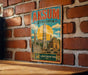 A vintage metal sign with the text "AKSUM" and "ETHIOPIA" is displayed on a brick wall.