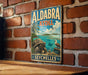 A vintage metal sign with a tropical beach scene, featuring a large tortoise, a bird, and a palm tree, mounted on a brick wall.