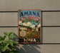 A vintage-style metal sign for the Amana Colonies in Iowa, featuring a windmill and a rural landscape.