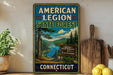 A vintage-style metal sign for the American Legion State Forest in Connecticut, featuring a scenic landscape with pine trees, a river, and mountains.