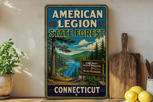 A vintage-style metal sign for the American Legion State Forest in Connecticut, featuring a scenic landscape with pine trees, a river, and mountains.