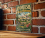 A vintage-style sign for "Andalusia Historic House & Gardens" is displayed on a brick wall, featuring an illustration of a historic house surrounded by gardens.