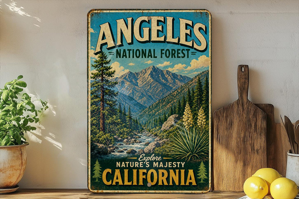 A vintage-style metal sign for the Angeles National Forest in California, featuring a scenic mountain landscape with pine trees, a river, and a waterfall.