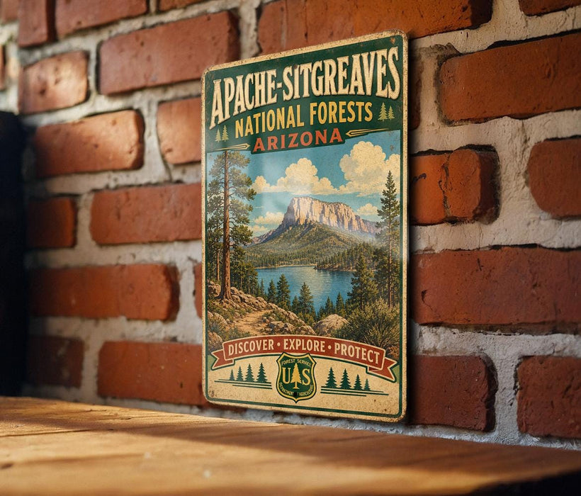A vintage-style metal sign for Apache-Sitting Greaves National Forests in Arizona, featuring a scenic landscape with mountains, trees, and a lake.