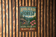 A vintage metal sign for the Appalachian Forest National Heritage Area in Maryland, featuring a scenic illustration of the forest and mountains.