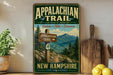 a vintage trail sign for the Appalachian Trail in New Hampshire, with a mountain landscape and pine trees in the background.