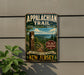 a vintage trail sign for the Appalachian Trail, mounted on a wall next to a plant.