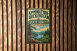 A vintage metal sign for Appomattox-Buckingham State Forest, Virginia, featuring a scenic landscape with pine trees, a lake, and mountains.