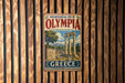 A vintage-style metal sign for the Archaeological Site of Olympia, Greece, featuring an illustration of ancient ruins and columns.