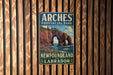 A vintage metal sign for the Arches Provincial Park in New Brunswick, Labrador, featuring a scenic image of the park's rock formations and landscape.