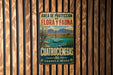 A vintage metal sign with text and an illustration of a natural landscape, mounted on a wooden wall.