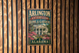 A vintage metal sign for "Arlington Antebellum Home & Gardens" in Alabama, featuring a house surrounded by flowers.