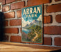 A vintage-style metal sign with the text "Arran Park" and "United Kingdom" is displayed on a brick wall.