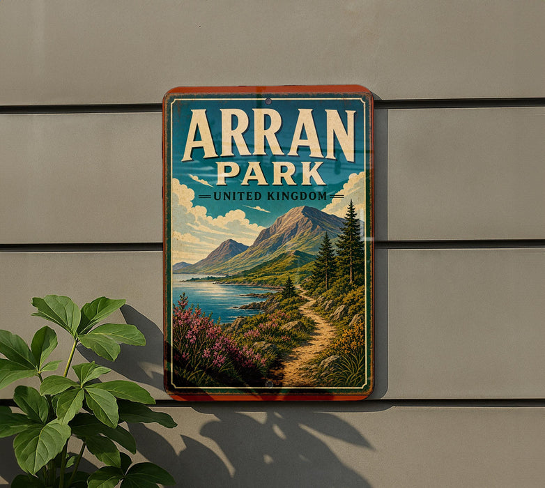 A vintage-style sign for Arran Park, United Kingdom, featuring a scenic landscape with mountains, a river, and a path leading through the greenery.