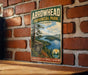A vintage-style metal sign for Arrowhead Provincial Park in Ontario, featuring a scenic landscape with a lake, mountains, and pine trees.